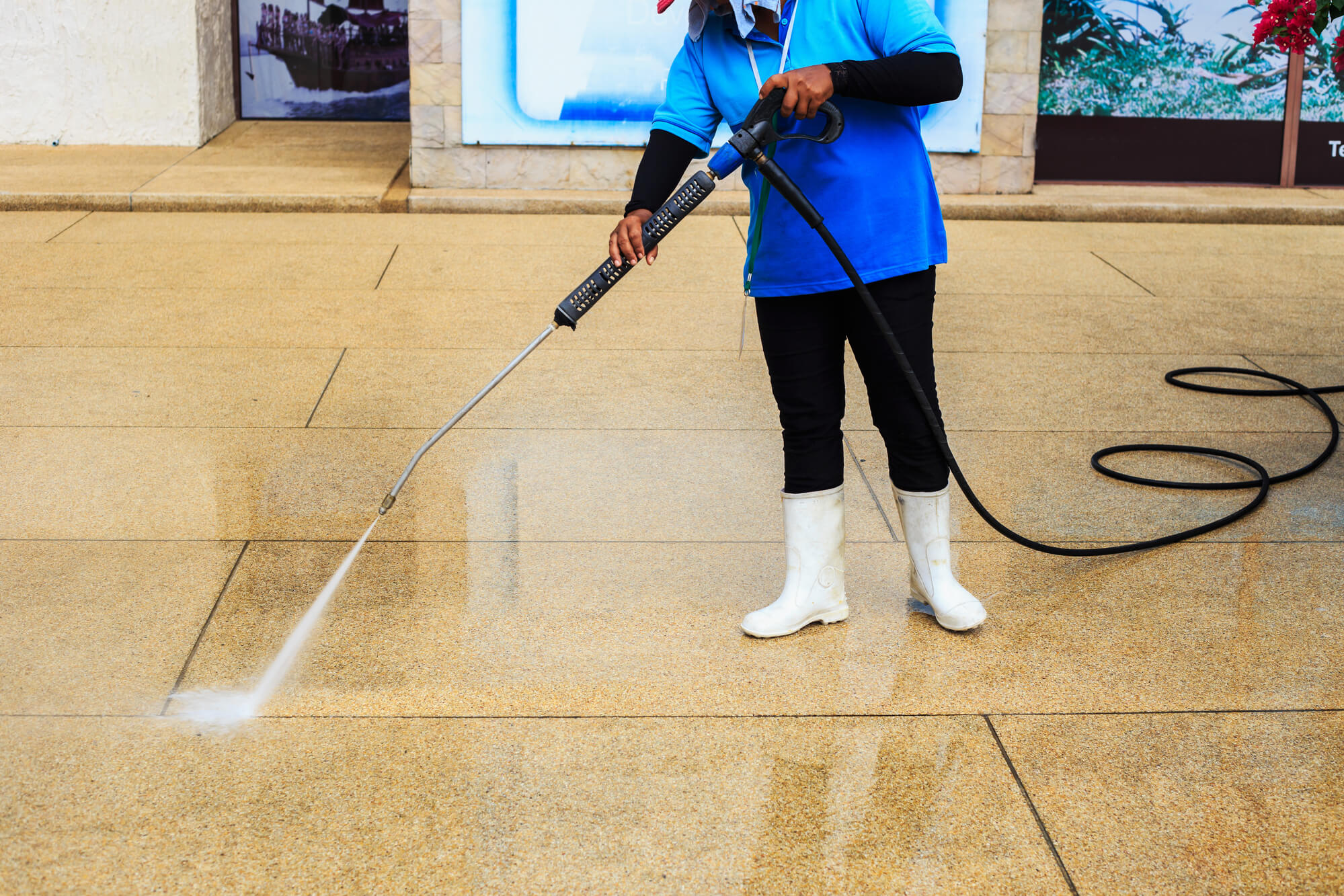 Worker pressure washing floor